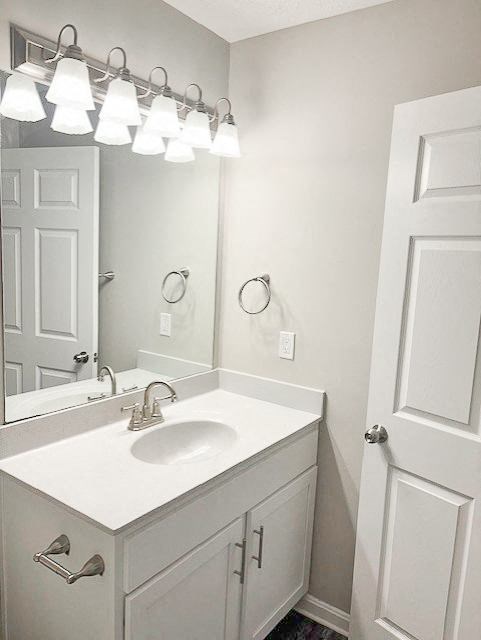A white bathroom with a sink and mirror.