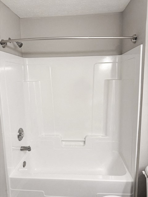 A white bathroom with a shower and a door.