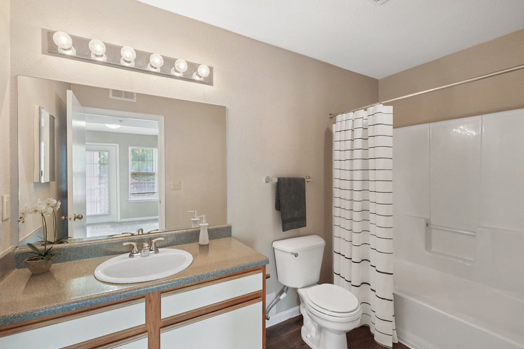 A bathroom with a sink, toilet, and shower.