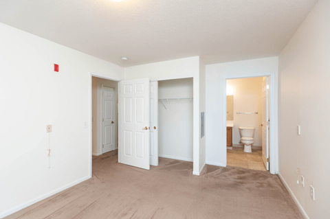 an empty room with white walls and doors and a bathroom