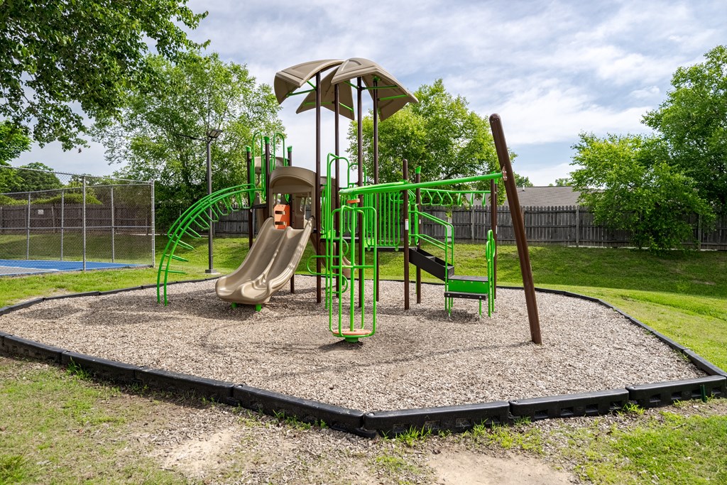 a playground with a swing set and slides in a park