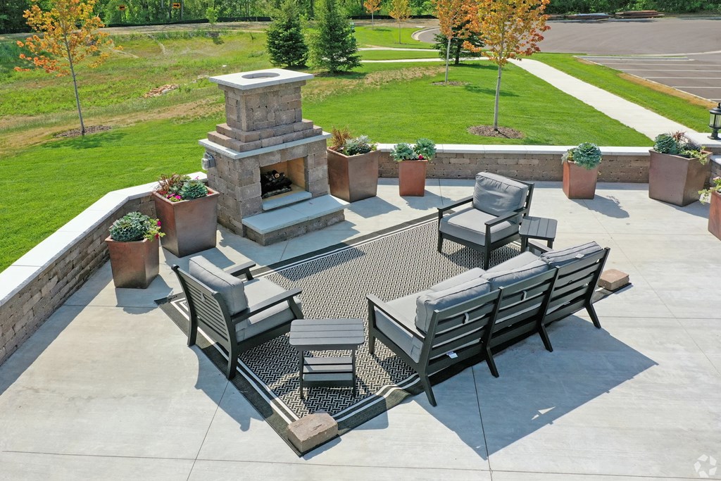an outdoor patio with a fireplace and chairs and tables