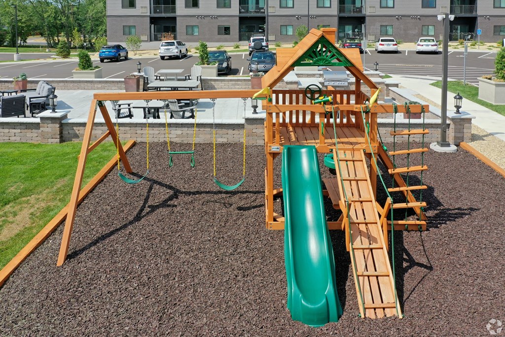 a swing set with a green slide in a park