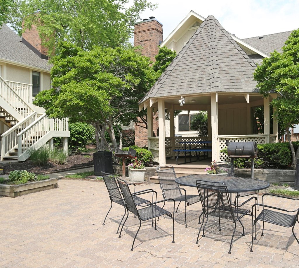 a patio with a table and chairs and a gazebo
