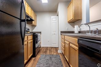 a kitchen with wood cabinets and black appliances