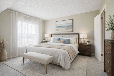 A bedroom with a large bed, a bench, and a painting on the wall.