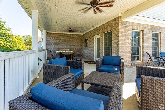 a covered patio with furniture and a ceiling fan