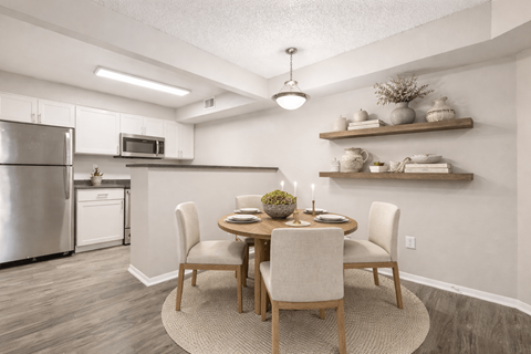 A modern kitchen with a dining table set for two.