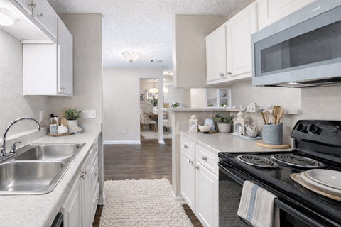 A kitchen with white cabinets and a black stove top.
