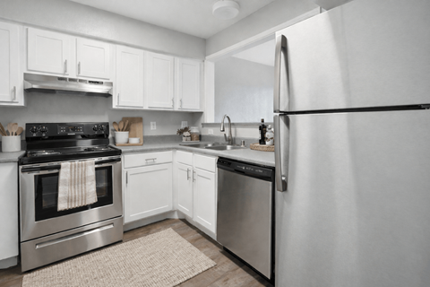 A modern kitchen with a stainless steel refrigerator, oven, and sink.