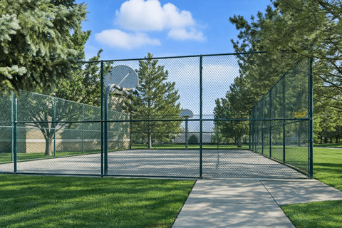 A fenced pathway in a park with trees on either side. at Diamond Fork Apartments, Spanish Fork, Utah
