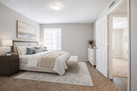 A bedroom with a bed, nightstand, and a painting on the wall at Haven Pointe Apartments, West Haven, Utah