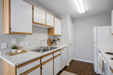 A kitchen with white cabinets and a white refrigerator.