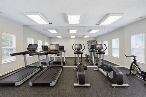A spacious gym with treadmills, exercise bikes, and other equipment.