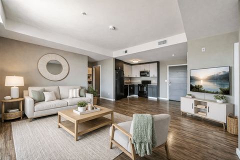 A modern living room with a grey couch, a wooden coffee table, and a flat screen TV.