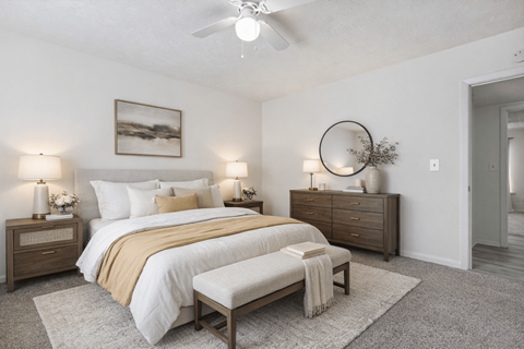 A bedroom with a bed, nightstands, and a rug.