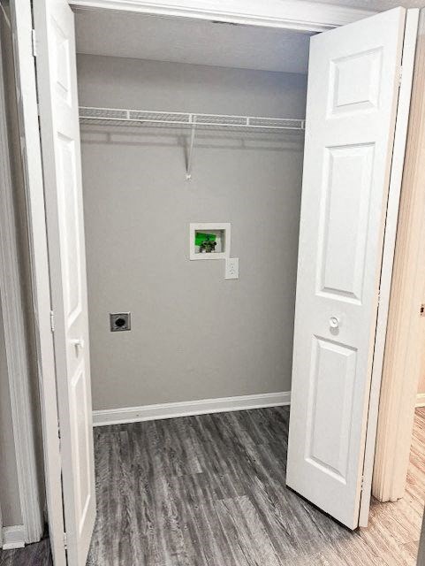 A white door is open to a small closet with a shelf and a light switch.