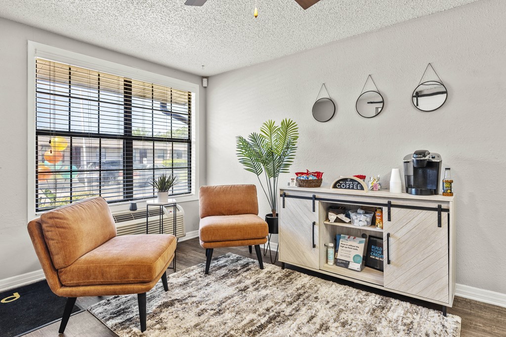 a living room with two chairs and a table and a window
