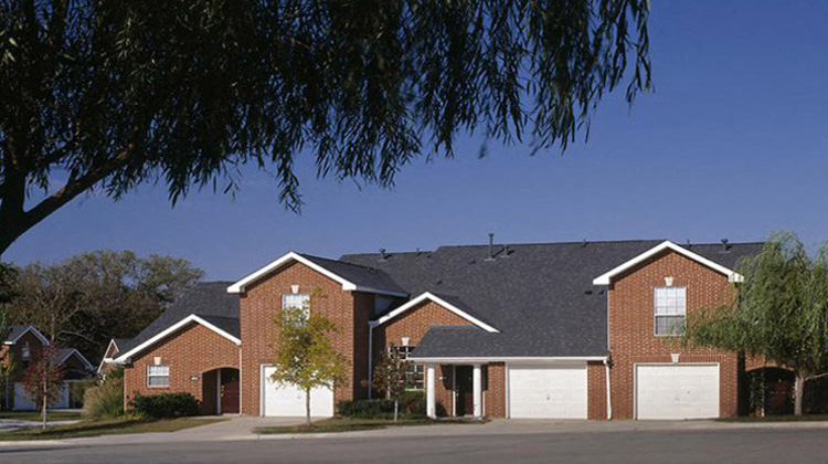 a house with a black roof and white garage doors