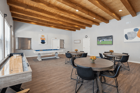 A billiard table is in a room with a pool table, a TV, and a dining table with chairs.
