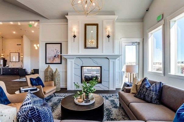 A living room with a fireplace and a brown couch. at Connect at First Creek Apartments, Denver, CO