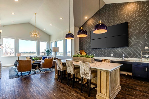 A kitchen with a large island and a dining table with chairs. at Connect at First Creek Apartments, Colorado, 80249
