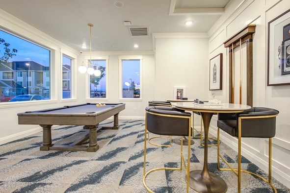 A room with a pool table and a table with chairs. at Connect at First Creek Apartments, Colorado