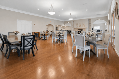 A large dining room with a wooden floor and white walls.