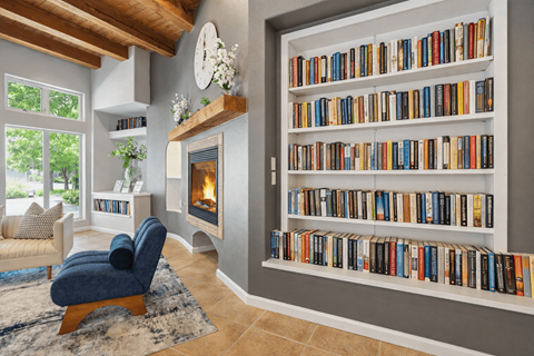 A living room with a fireplace and a bookshelf filled with books.