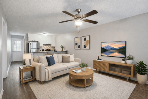 A living room with a couch, a coffee table, and a painting on the wall.