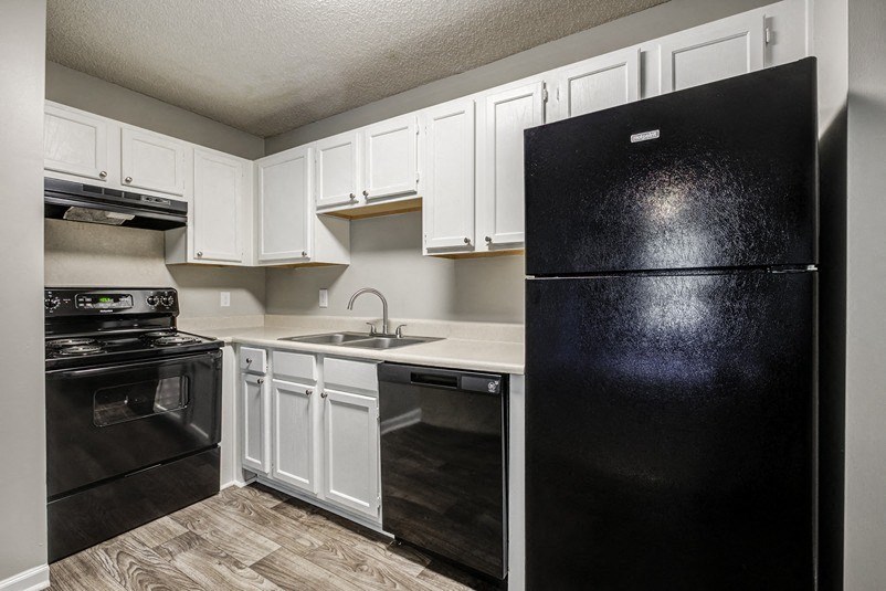 a kitchen with black appliances and white cabinets