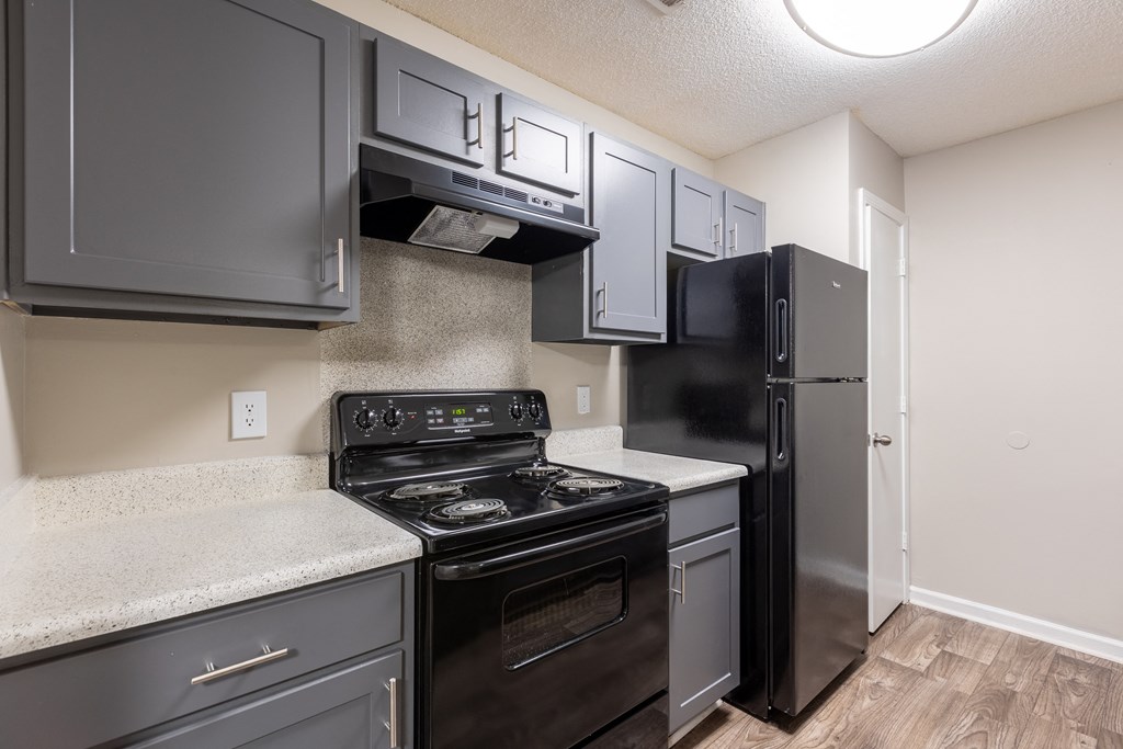 a kitchen with black appliances and white counter tops and a black refrigerator