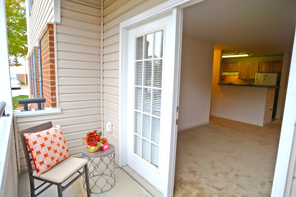 a small porch with a chair and a table on it