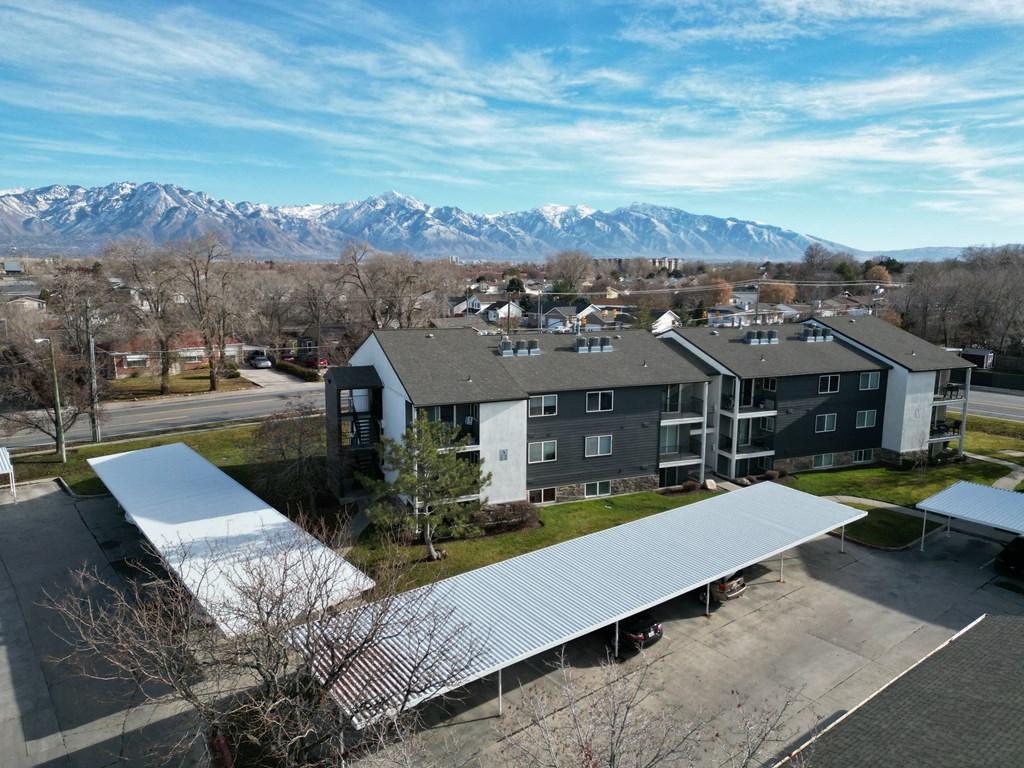 an aerial view of a building with mountains in the background