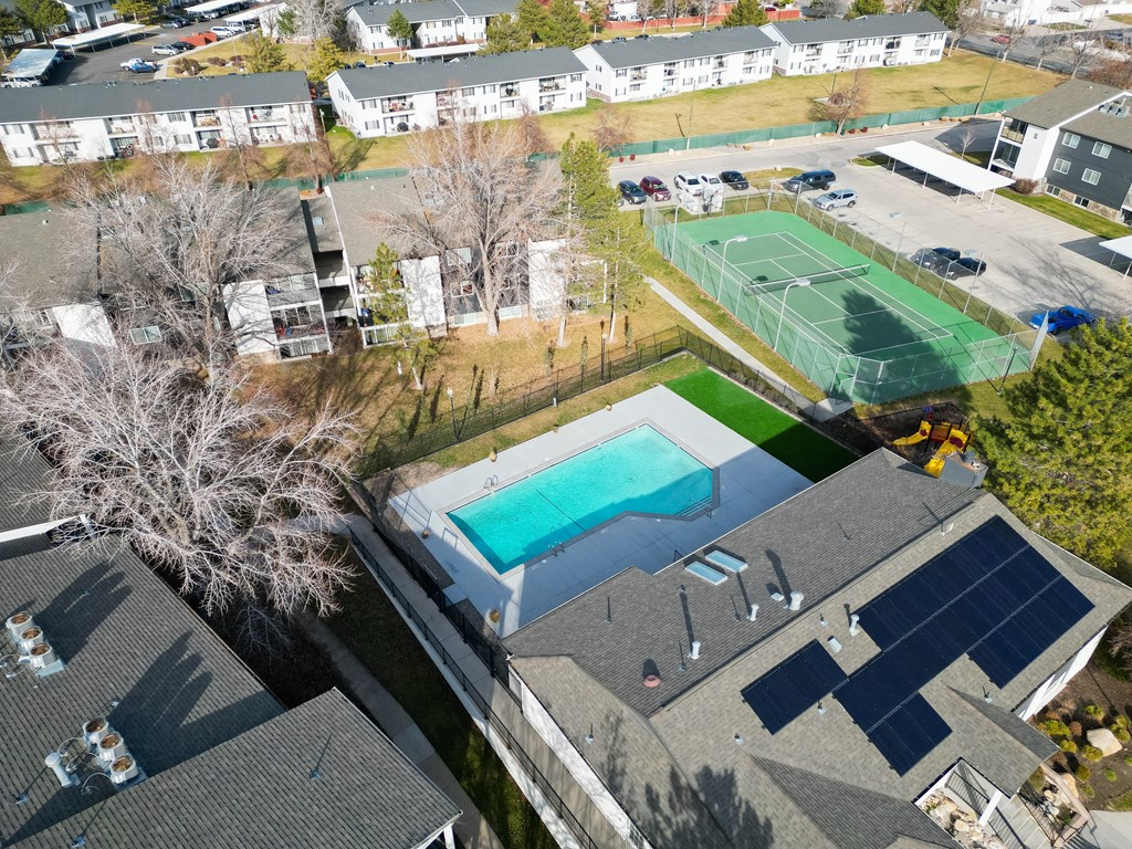 an aerial view of a house with a swimming pool and tennis court