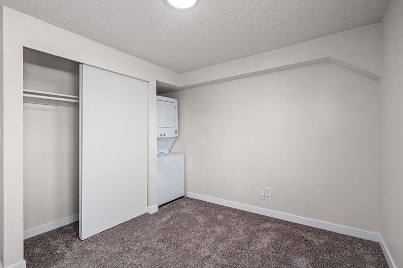 a bedroom with a closet and a washer and dryer