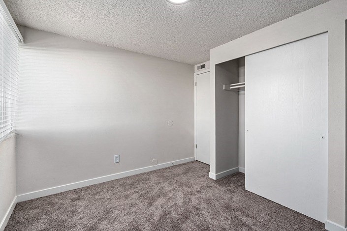 a bedroom with a closet and a window