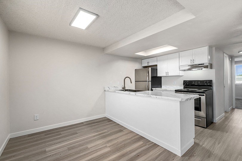 a kitchen with white cabinets and a stainless steel stove