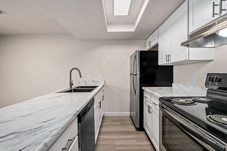 a kitchen with white cabinets and black appliances