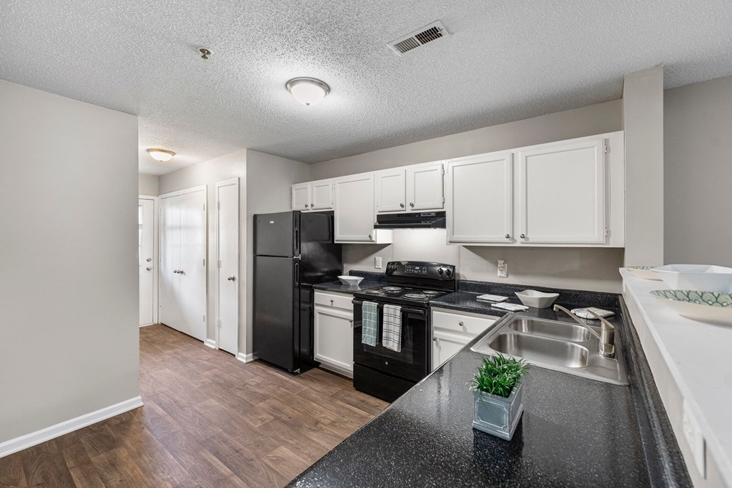 the preserve at ballantyne commons apartment kitchen with black appliances and white cabinets