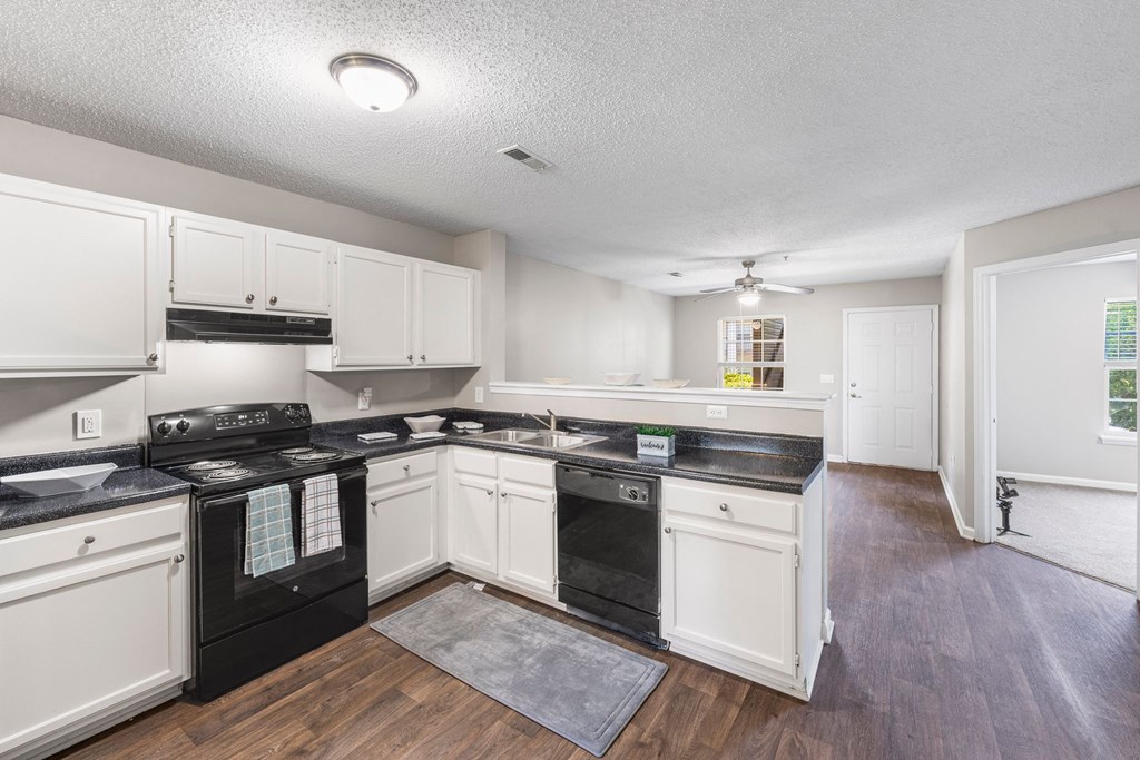 a kitchen with white cabinets and black appliances
