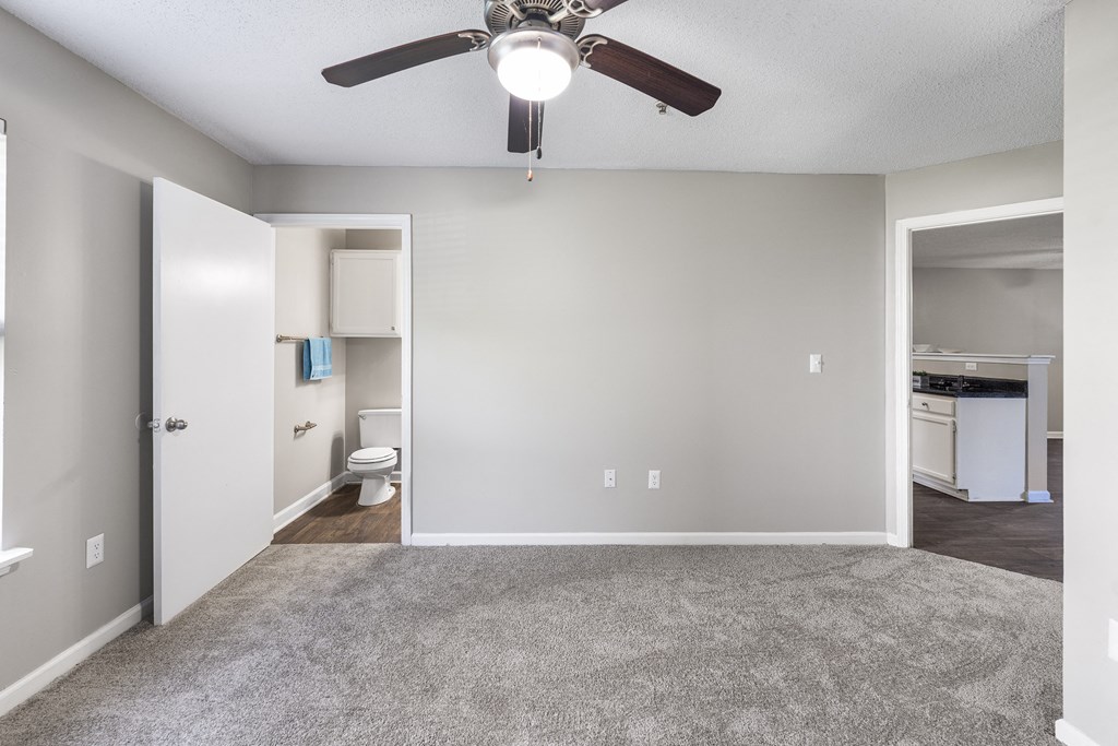 an empty living room with a ceiling fan