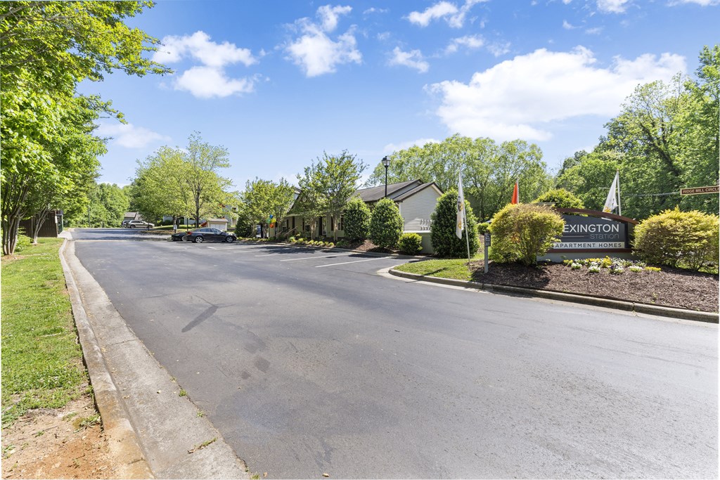 a street in front of a church with trees and a sign