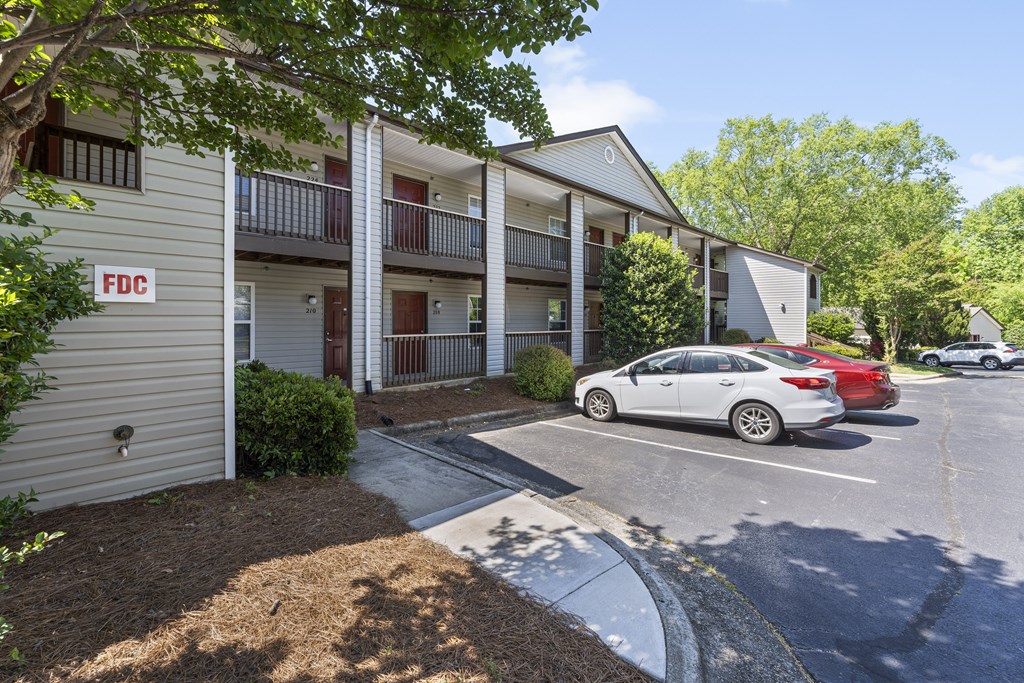 an apartment building with a parking lot and cars parked in front