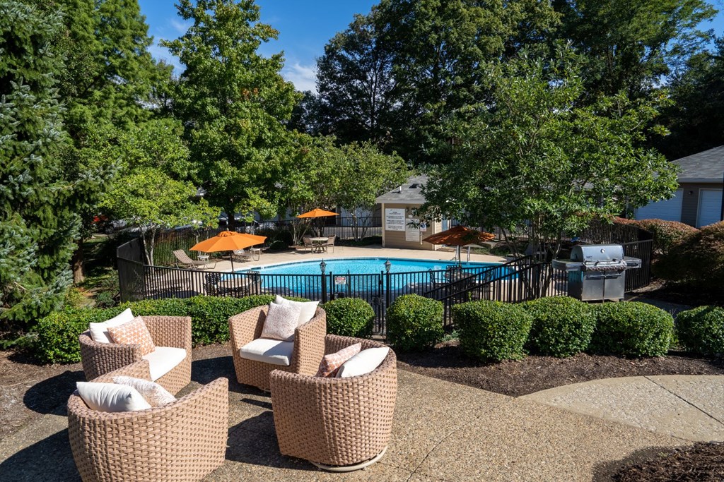 a patio with chairs and a pool in a backyard