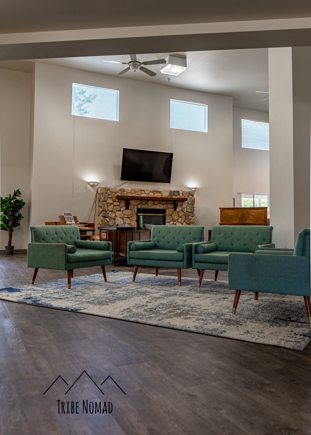 a living room with green chairs and a fireplace