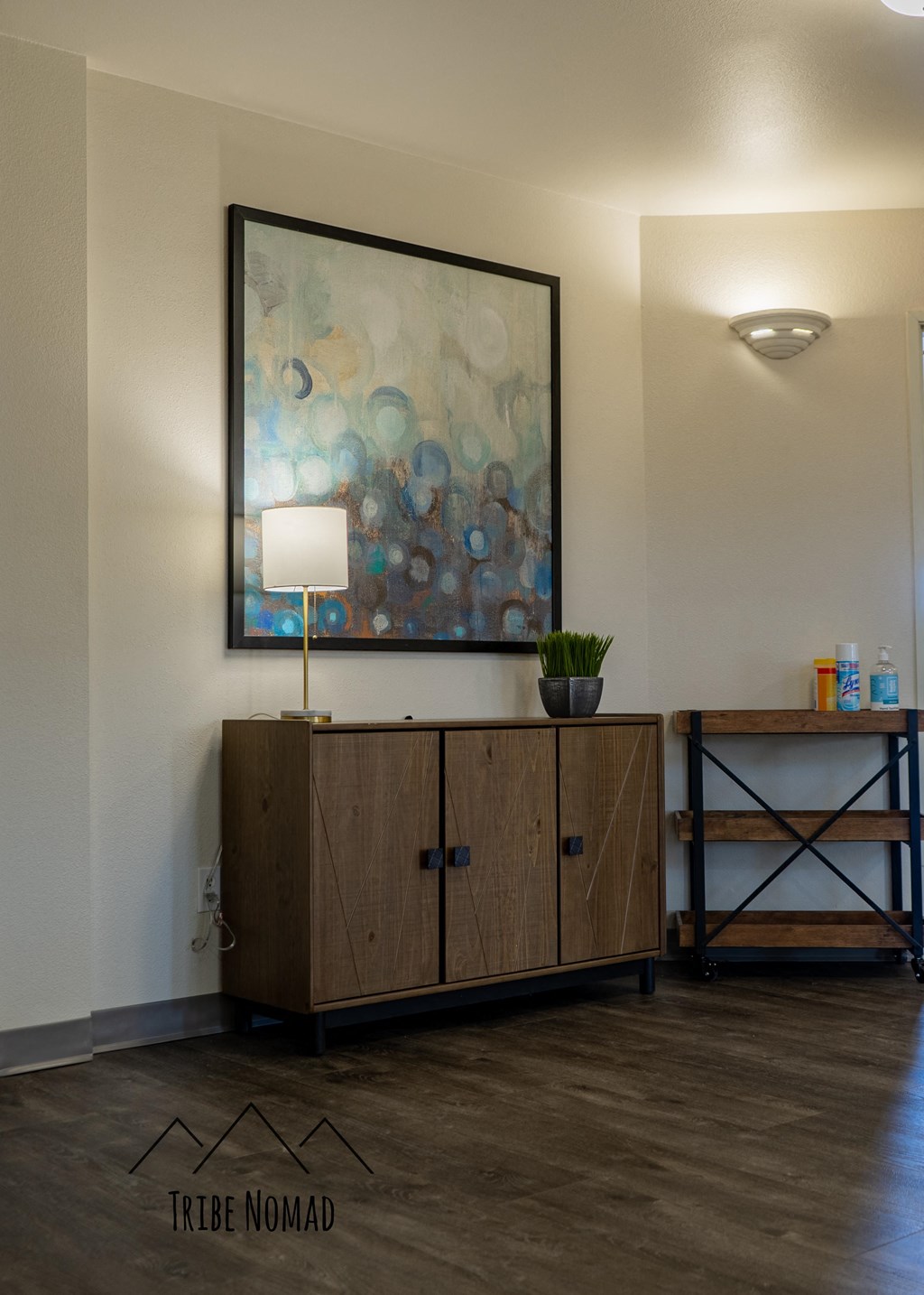 a living room with a cabinet and a painting on the wall