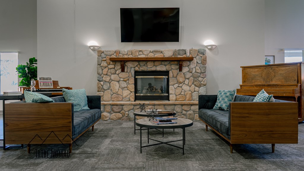 a living room with a stone fireplace and furniture