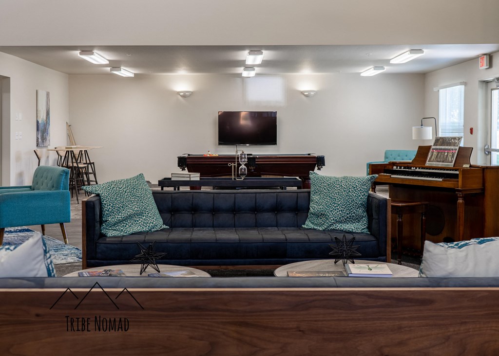 a living room with a blue couch and a piano