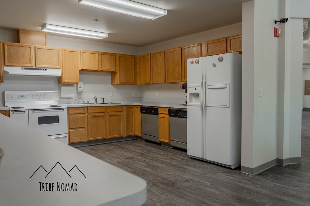 an empty kitchen with white appliances and wooden cabinets